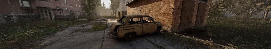 Coche oxidado junto a un garaje de ladrillo en Prípiat